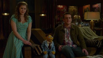 Movie still from “The Muppets” (2011), directed by James Bobin – A man and a woman sitting next to a man with a puppet; Medium shot, Over the shoulder angle