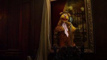 Movie still from “The Muppets” (2011), directed by James Bobin – A picture of the muppets character fozzie bear; Wide shot, Over the shoulder angle