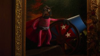 Movie still from “The Muppets” (2011), directed by James Bobin – A painting of a man in a pink suit and a red cape; Wide shot, Low angle