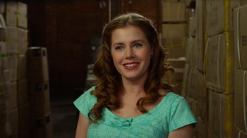 Movie still from “The Muppets” (2011), directed by James Bobin – A person wearing a dress smiling; Close Up shot, Over the shoulder angle