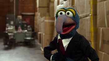 Movie still from “The Muppets” (2011), directed by James Bobin – A person wearing a suit and tie with a bird head; Medium shot, Over the shoulder angle