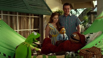 Movie still from “The Muppets” (2011), directed by James Bobin – A man and a woman standing next to stuffed animals; Medium shot, High angle