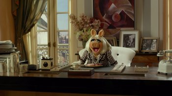 Movie still from “The Muppets” (2011), directed by James Bobin – A person sitting at a desk with a pig mask on; Medium shot, High angle