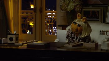 Movie still from “The Muppets” (2011), directed by James Bobin – A woman sitting at a desk with a laptop; Medium shot, High angle