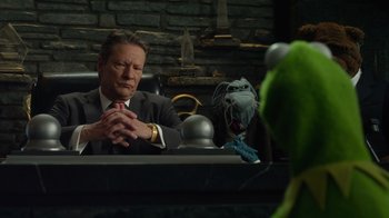 Movie still from “The Muppets” (2011), directed by James Bobin – A man sitting in front of a green monster; Medium shot, Over the shoulder angle