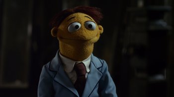 Movie still from “The Muppets” (2011), directed by James Bobin – The head of a puppet wearing a suit and tie; Close Up shot, Low angle