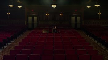 Movie still from “The Muppets” (2011), directed by James Bobin – A person sitting in a theater with red seats; Extreme Wide shot, High angle