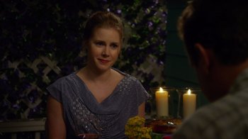 Movie still from “The Muppets” (2011), directed by James Bobin – A woman sitting at a table with candles in front of her; Medium shot, Over the shoulder angle
