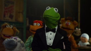 Movie still from “The Muppets” (2011), directed by James Bobin – A man in a suit and a kermit the frog mask; Medium shot, Over the shoulder angle