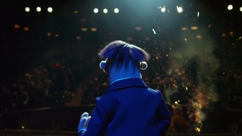 Movie still from “The Muppets” (2011), directed by James Bobin – A person with blue hair is standing in front of a stage; Medium shot, Low angle