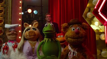 Movie still from “The Muppets” (2011), directed by James Bobin – A group of muppets sitting next to each other in front of a red curtain; Medium shot, Over the shoulder angle