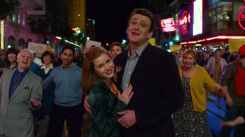 Movie still from “The Muppets” (2011), directed by James Bobin – A man and a woman are posing for a picture in front of a crowd of onlookers; Medium shot, Low angle