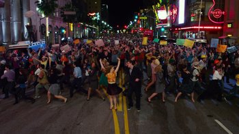 Movie still from “The Muppets” (2011), directed by James Bobin – A large group of people are marching down the street; Extreme Wide shot, High angle