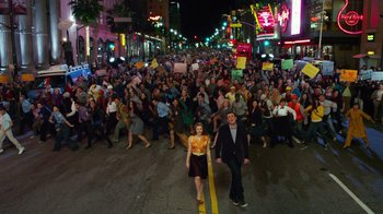 Movie still from “The Muppets” (2011), directed by James Bobin – A crowd of people walking down a street at night; Extreme Wide shot, High angle