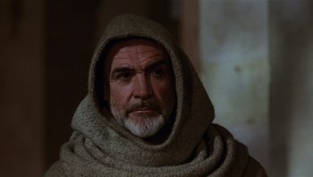 Movie still from “The Name of the Rose” (1986), directed by Jean-Jacques Annaud – An older man with a beard wearing a hood; Close Up shot, Low angle