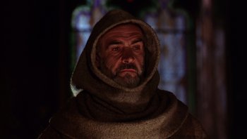Movie still from “The Name of the Rose” (1986), directed by Jean-Jacques Annaud – A man with a beard wearing a hooded robe; Close Up shot, Low angle