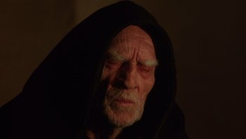 Movie still from “The Name of the Rose” (1986), directed by Jean-Jacques Annaud – An old man wearing a black hooded sweatshirt; Close Up shot, Low angle