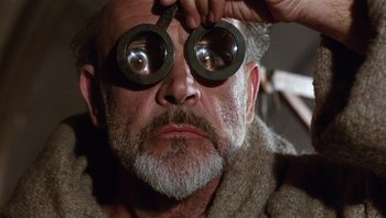 Movie still from “The Name of the Rose” (1986), directed by Jean-Jacques Annaud – An older man with a pair of glasses on his eyes; Close Up shot, Low angle