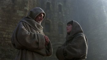 Movie still from “The Name of the Rose” (1986), directed by Jean-Jacques Annaud – A man and a woman dressed in robes and cloaks; Medium shot, Low angle