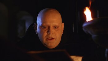 Movie still from “The Name of the Rose” (1986), directed by Jean-Jacques Annaud – A man with a bald head is looking at the camera; Close Up shot, Low angle