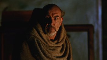 Movie still from “The Name of the Rose” (1986), directed by Jean-Jacques Annaud – An old man with a beard and a towel around his neck; Close Up shot, Low angle