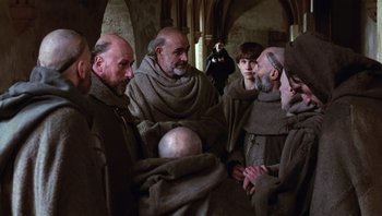 Movie still from “The Name of the Rose” (1986), directed by Jean-Jacques Annaud – A group of men in brown robes standing around each other; Medium shot, High angle