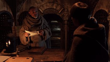 Movie still from “The Name of the Rose” (1986), directed by Jean-Jacques Annaud – A man wearing a monk's robe is reading a letter; Medium shot, Low angle