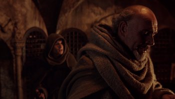 Movie still from “The Name of the Rose” (1986), directed by Jean-Jacques Annaud – A man and a woman sitting next to each other; Medium shot, Over the shoulder angle