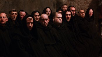 Movie still from “The Name of the Rose” (1986), directed by Jean-Jacques Annaud – A group of men wearing black robes and hoods; Wide shot, High angle