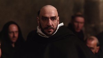 Movie still from “The Name of the Rose” (1986), directed by Jean-Jacques Annaud – A man with a bald head wearing a monk's outfit; Close Up shot, Low angle