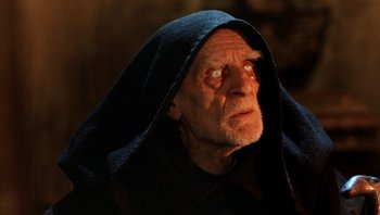 Movie still from “The Name of the Rose” (1986), directed by Jean-Jacques Annaud – An old man wearing a black hooded robe looking up; Close Up shot, Low angle