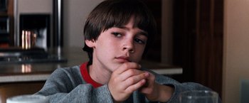 Movie still from “The NeverEnding Story” (1984), directed by Wolfgang Petersen – A young boy is holding his hands to his face; Close Up shot, High angle