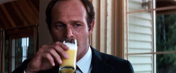 Movie still from “The NeverEnding Story” (1984), directed by Wolfgang Petersen – A person drinking a glass of orange juice; Close Up shot, Over the shoulder angle