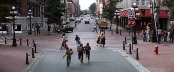 Movie still from “The NeverEnding Story” (1984), directed by Wolfgang Petersen – A group of children walking across a street in a city; Extreme Wide shot, High angle