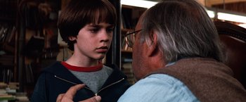 Movie still from “The NeverEnding Story” (1984), directed by Wolfgang Petersen – An older man and a young boy looking at each other; Close Up shot, Over the shoulder angle