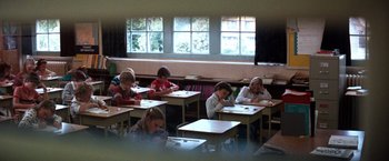 Movie still from “The NeverEnding Story” (1984), directed by Wolfgang Petersen – A group of children sitting at desks in a classroom; Wide shot, High angle