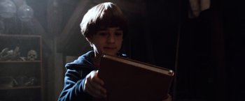 Movie still from “The NeverEnding Story” (1984), directed by Wolfgang Petersen – A boy holding a book in his hands; Close Up shot, Low angle