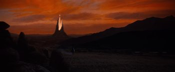 Movie still from “The NeverEnding Story” (1984), directed by Wolfgang Petersen – A person riding a horse in the desert at sunset; Extreme Wide shot, Low angle