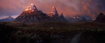 Movie still from “The NeverEnding Story” (1984), directed by Wolfgang Petersen – A painting of a mountain range at sunset; Extreme Wide shot, Low angle