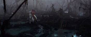 Movie still from “The NeverEnding Story” (1984), directed by Wolfgang Petersen – A man sitting on top of a white horse in the woods; Extreme Wide shot, High angle