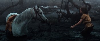 Movie still from “The NeverEnding Story” (1984), directed by Wolfgang Petersen – A white horse is standing in the middle of a swamp; Wide shot, High angle