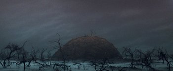 Movie still from “The NeverEnding Story” (1984), directed by Wolfgang Petersen – A large rock sitting in the middle of a field; Extreme Wide shot, Low angle