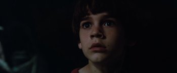 Movie still from “The NeverEnding Story” (1984), directed by Wolfgang Petersen – A young boy looking into the distance in the dark; Close Up shot, Low angle