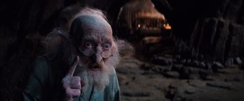 Movie still from “The NeverEnding Story” (1984), directed by Wolfgang Petersen – An old man with long white hair and a long beard; Close Up shot, Low angle