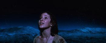 Movie still from “The NeverEnding Story” (1984), directed by Wolfgang Petersen – A woman standing in the dark with a sky in the background; Close Up shot, Low angle