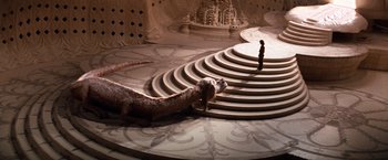 Movie still from “The NeverEnding Story” (1984), directed by Wolfgang Petersen – A lizard is sitting on the steps of a building; Extreme Wide shot, High angle
