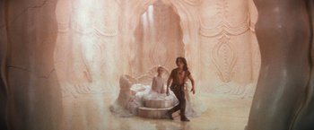 Movie still from “The NeverEnding Story” (1984), directed by Wolfgang Petersen – A man standing next to a woman in a white dress; Wide shot, High angle