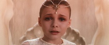 Movie still from “The NeverEnding Story” (1984), directed by Wolfgang Petersen – A young girl wearing a head piece with pearls on her head; Close Up shot, High angle