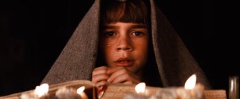 Movie still from “The NeverEnding Story” (1984), directed by Wolfgang Petersen – A young boy is wrapped in a blanket; Close Up shot, High angle