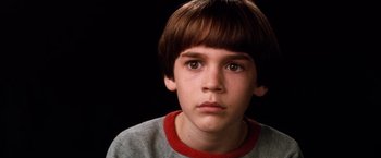 Movie still from “The NeverEnding Story” (1984), directed by Wolfgang Petersen – A young boy is looking at the camera; Close Up shot, High angle